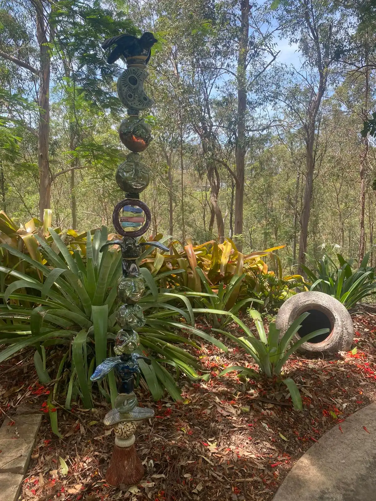 The studio garden: a ceramic totem among bromeliads under tall gum trees