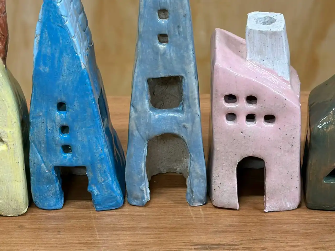 Three tall ceramic houses glazed blue and pink