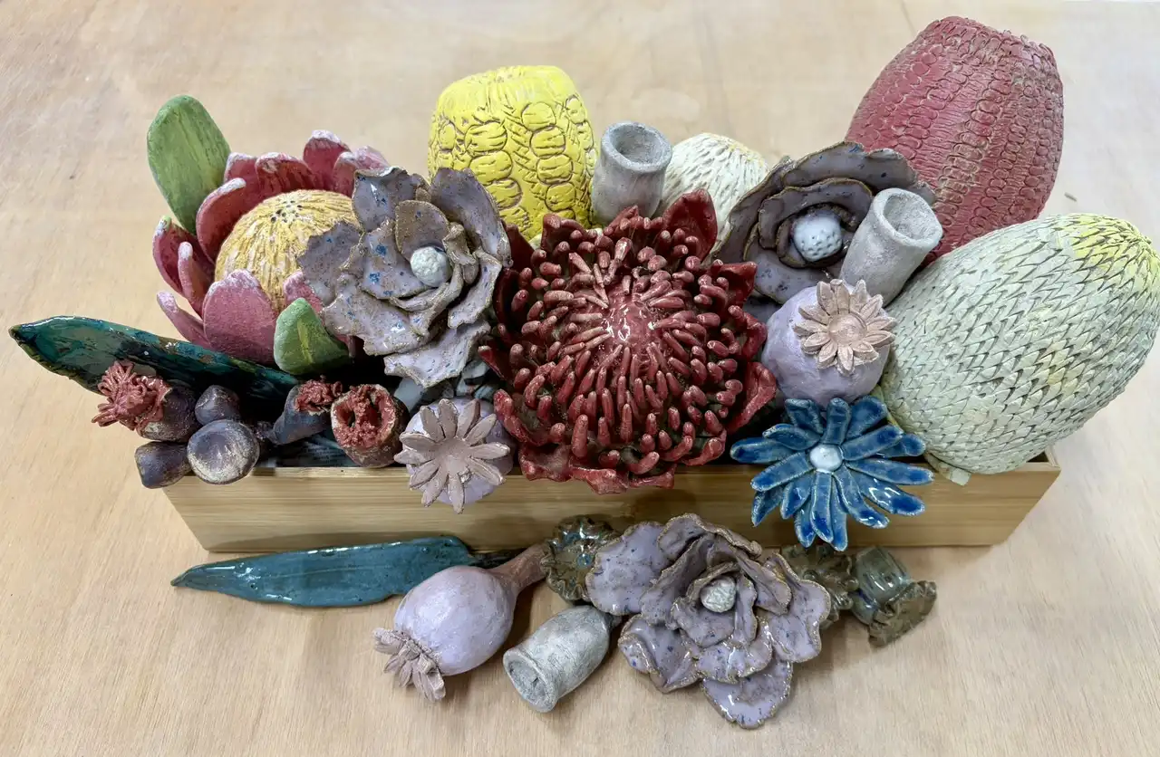 Hand-built ceramic native flowers, glazed in reds, blues and yellows